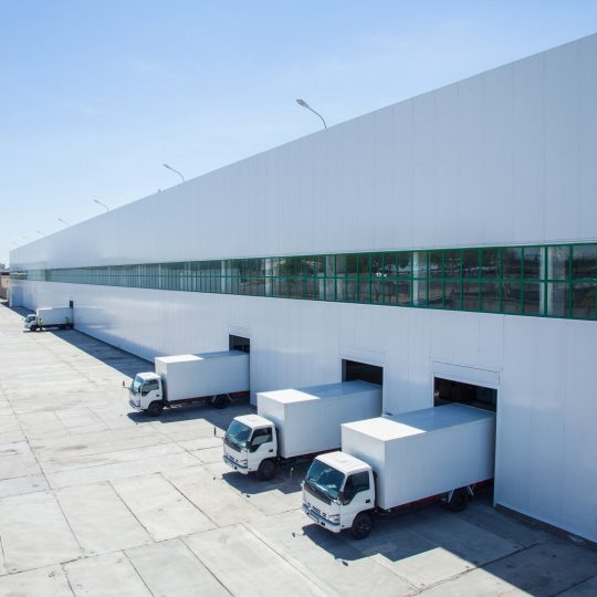 facade of an industrial building and warehouse with freight cars in length